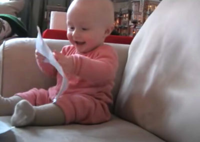 Baby laughing hysterically at ripping paper